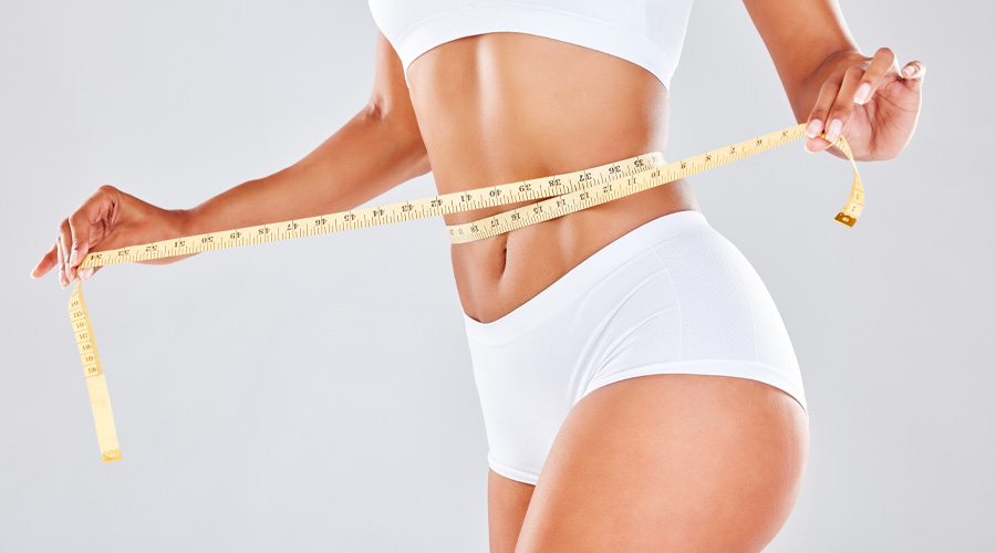 woman measuring her waistline