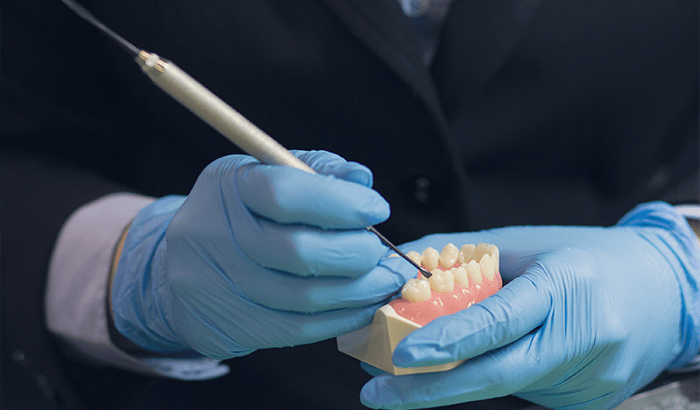 Oral surgeons hand working on model of teeth at Virginia Surgical Arts in Virginia Beach, VA.