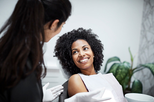 Young woman smiling at dental assistant during wisdom teeth consultation at Virginia Surgical Arts in Virginia Beach, VA