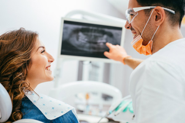 A female patient smiling at oral surgeon explaining dental implant process at Virginia Surgical Arts in Virginia Beach, VA