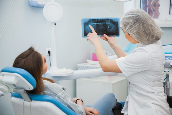 Oral surgeon explaining x-rays to patient during dental implant consultation at Virginia Surgical Arts in Virginia Beach, VA